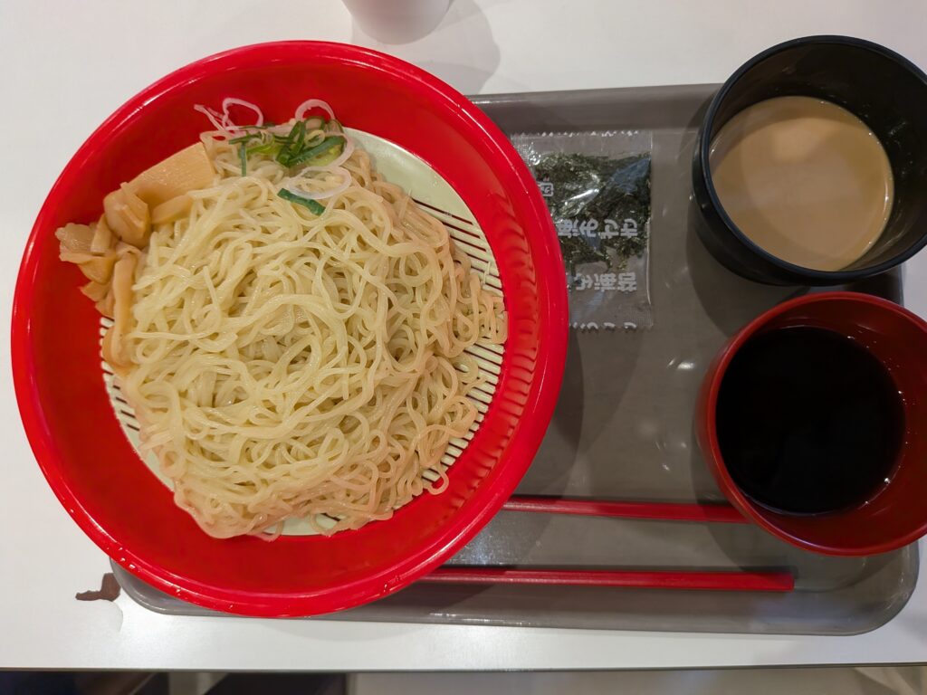 35 日目・昼食:スガキヤのざるラーメン:赤い器に盛った冷たい細麺とメンマ・ネギ、横に海苔小袋とごまだれ・つゆのカップ